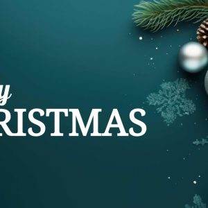 Festive Merry Christmas greeting with ornaments and evergreen branches on a teal background.