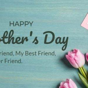 Pink tulips and a Mother's Day card on a blue wooden table with a heartfelt message