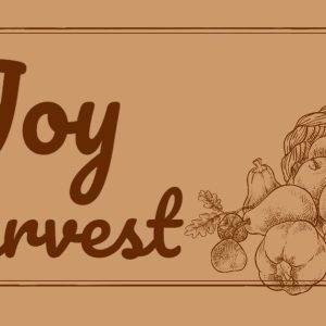 Autumn harvest festival banner featuring a cornucopia with fruits and vegetables, and the phrase "The Joy of the Harvest."