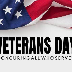 American flag background with the text 'Veterans Day: Honouring All Who Served'.