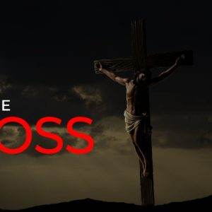 A shadowed depiction of Jesus on the cross with "At The Cross" in bold text.