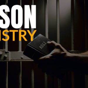 Person holding a Bible in front of prison bars for prison ministry.