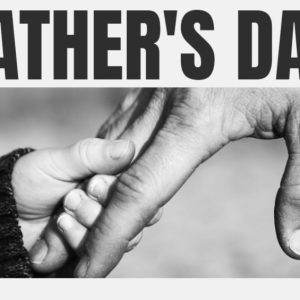 Child holding hands with father in black and white with Father’s Day text.