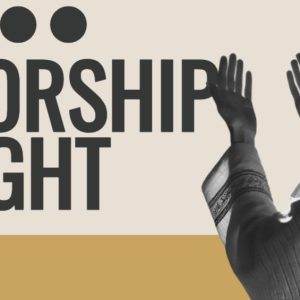 Person with raised hands at Worship Night event with modern design elements.