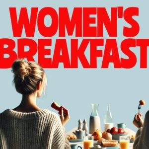 Two women enjoying a breakfast spread with pastries, fruits, and beverages under a bold "Women's Breakfast" sign.