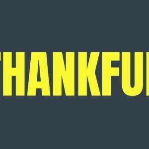 Hands holding autumn leaves with the word Thankful in bold yellow letters