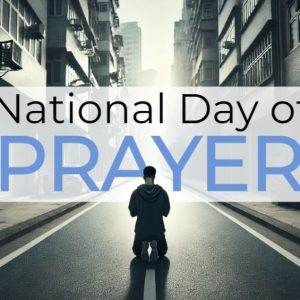 Person kneeling in prayer on an empty city street for National Day of Prayer