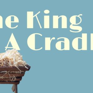 Manger with straw set against a teal background and bold text reading "The King in a Cradle"