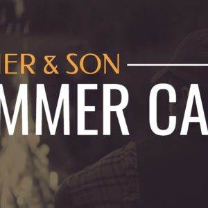 Father and Son Summer Camp sign with warm campfire in the background.